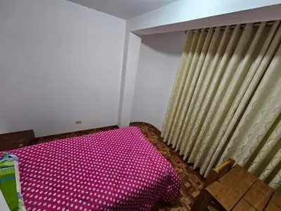 a bedroom with a pink bed and a window at Munay Ayllu- Tu refugio familiar en Huánuco in Huánuco