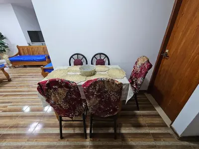 a dining room with a table and chairs with a table cloth at Munay Ayllu- Tu refugio familiar en Huánuco in Huánuco
