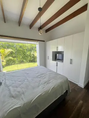a bedroom with a large bed and a large window at Condominio ecológico las gardenias de Asia in Asia