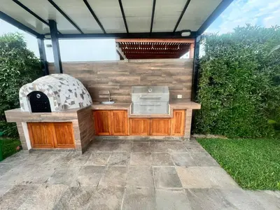 an outdoor kitchen with a grill and a microwave at Condominio ecológico las gardenias de Asia in Asia