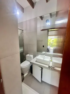 a white bathroom with a toilet and a sink at Condominio ecológico las gardenias de Asia in Asia