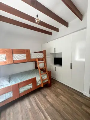 a room with two bunk beds and a kitchen at Condominio ecológico las gardenias de Asia in Asia