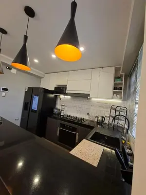 a kitchen with a black counter top and two lights at Beach House - Besso Beach in Barranca
