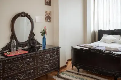 a bedroom with a black dresser and a mirror at Moty's Guesthouse in Cusco