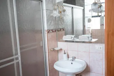a bathroom with a sink and a shower at Moty's Guesthouse in Cusco