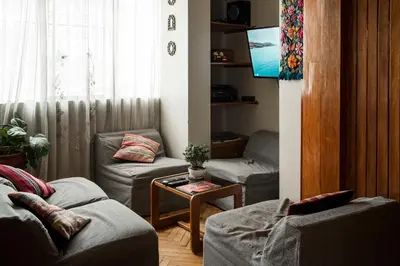 a living room with two couches and a tv at Moty's Guesthouse in Cusco