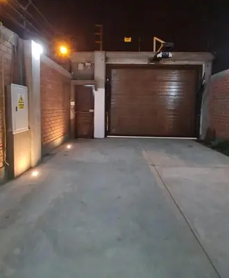 an empty garage with two garage doors at night at Chilca, ATM Beach House in Salinas