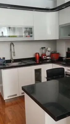 a kitchen with white cabinets and a black counter top at Chilca, ATM Beach House in Salinas