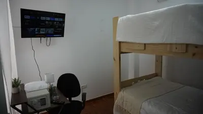 a bedroom with a bunk bed with a tv on the wall at Chilca, ATM Beach House in Salinas