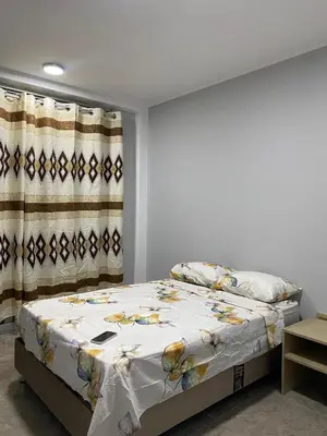 a bedroom with a bed with a white blanket and curtains at Ruta del Oasis - Huacachina in Ica