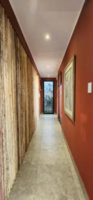 a hallway with orange walls and a tile floor at Quiet 3BR Country Villa whit BBQ in Ica
