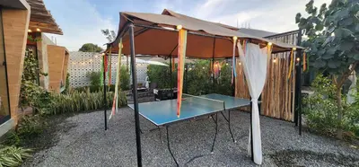 a table with an umbrella in a garden at Quiet 3BR Country Villa whit BBQ in Ica