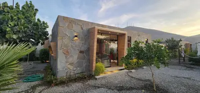 a small house with a stone wall at Quiet 3BR Country Villa whit BBQ in Ica