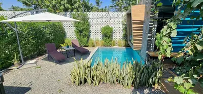 a swimming pool with two chairs and an umbrella at Quiet 2BR Villa whit Pool & Games in Ica