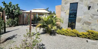 a garden with a umbrella and a building at Quiet 2BR Villa whit Pool & Games in Ica