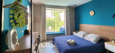 a bedroom with a bed with blue walls and a window at Quiet 2BR Villa whit Pool & Games in Ica