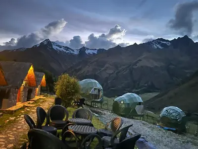 a group of tents with mountains in the background at Salkantay House in Anta