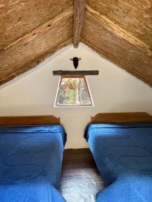 two beds in a room with a window at Salkantay House in Anta