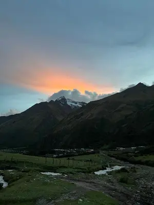 a view of a mountain range with the sun setting at Salkantay House in Anta