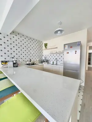 a kitchen with a white counter and a refrigerator at Modern apartment a short walk from the boulevard and beach in Punta Hermosa