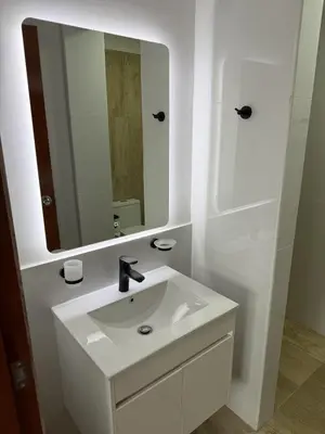a white bathroom with a sink and a mirror at Casa de Playa de Estreno in San Antonio
