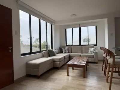 a living room with a couch and a table and windows at Casa de Playa de Estreno in San Antonio