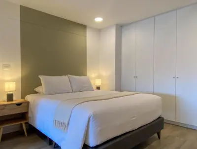 a bedroom with a large white bed and a cabinet at Enchanting Loft with Balcony in Barranco in Lima