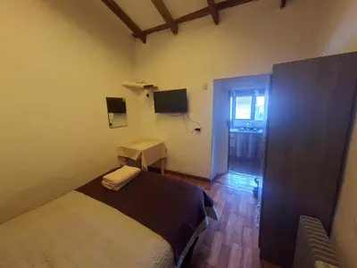 a bedroom with a bed and a table and a window at Acogedor Departamento Vitoque in Cusco