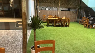 a restaurant with a table and chairs and a potted plant at Casa de Playa - Mara House in Huacho