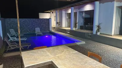 a swimming pool in a house with a table and chairs at Casa de Playa - Mara House in Huacho