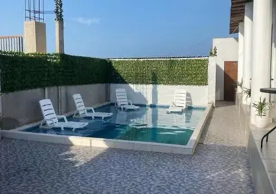 a swimming pool with chairs and a swimming poolvisor at Casa de Playa - Mara House in Huacho