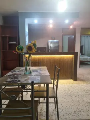 a table and chairs with a vase of flowers on it at Departamento en Ica super céntrico en Urb San Miguel in Ica