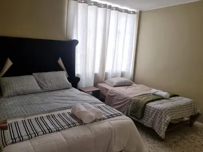 a bedroom with two beds and a window at Departamento en Ica super céntrico en Urb San Miguel in Ica
