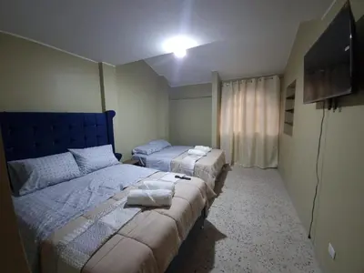 a bedroom with two beds and a television in it at Departamento en Ica super céntrico en Urb San Miguel in Ica