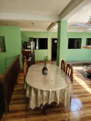 a dining room with a table and chairs and green walls at Posada del Carmen in Quillabamba