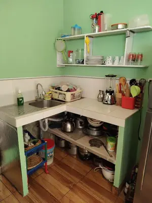 a kitchen with a counter with a sink and shelves at Posada del Carmen in Quillabamba