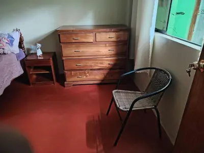 a bedroom with a dresser and a chair and a desk at Posada del Carmen in Quillabamba