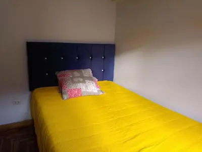 a bedroom with a yellow bed with a pillow on it at El despertar del inka in Cusco