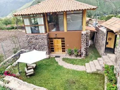a small house with a table and a building at Beautiful house in the Sacred Valley, Arin Falls in Calca