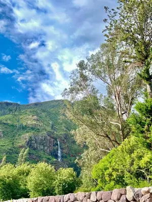 a waterfall in the middle of a mountain with trees at Beautiful house in the Sacred Valley, Arin Falls in Calca