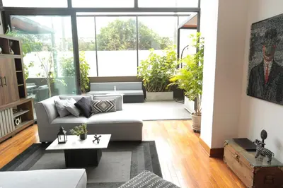 a living room with a couch and a table at Diseño, Luz Natural y Jardín Privado en Loft in Lima