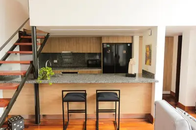 a kitchen with two black stools at a counter at Diseño, Luz Natural y Jardín Privado en Loft in Lima