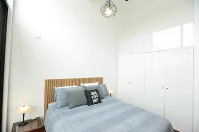 a bedroom with a bed with a blue blanket at Diseño, Luz Natural y Jardín Privado en Loft in Lima