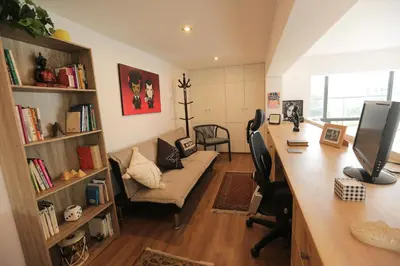 a home office with a desk and a computer and a couch at Diseño, Luz Natural y Jardín Privado en Loft in Lima