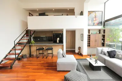 a living room with a white couch and a kitchen at Diseño, Luz Natural y Jardín Privado en Loft in Lima