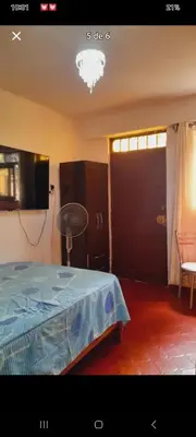 a bedroom with a bed and a tv and a door at Habitación en Barranco in Lima