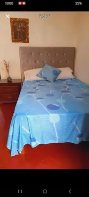 a bed in a bedroom with a blue comforter at Habitación en Barranco in Lima