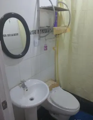 a bathroom with a sink and a toilet and a mirror at Habitación en Barranco in Lima