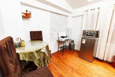 a living room with a table and a refrigerator at Mayu House Inn a minutos del centro histórico in Cusco