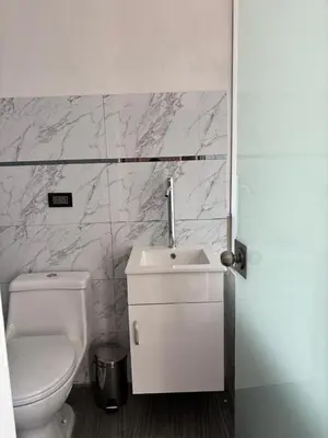 a white bathroom with a toilet and a sink at Hotel Roma Quillabamba in Quillabamba